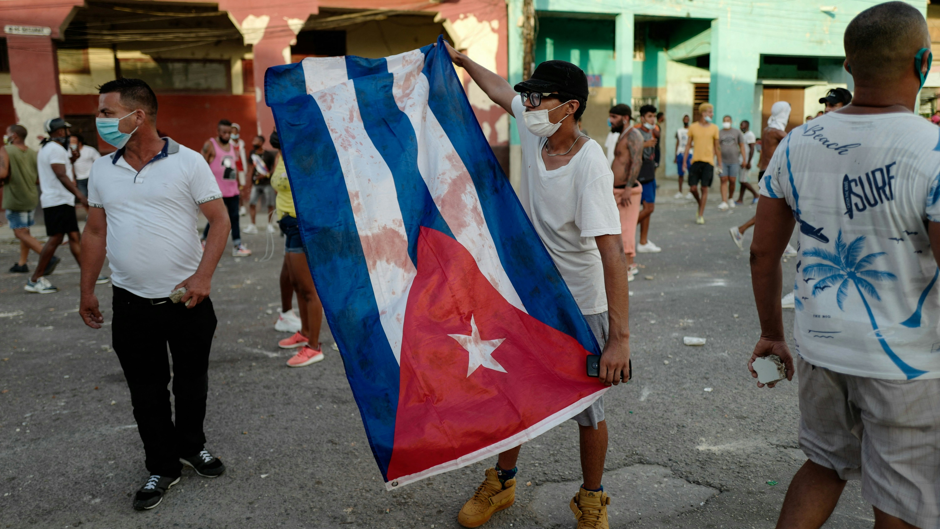 A man waves a Cuban flag during a demonstration against the government of Cuba