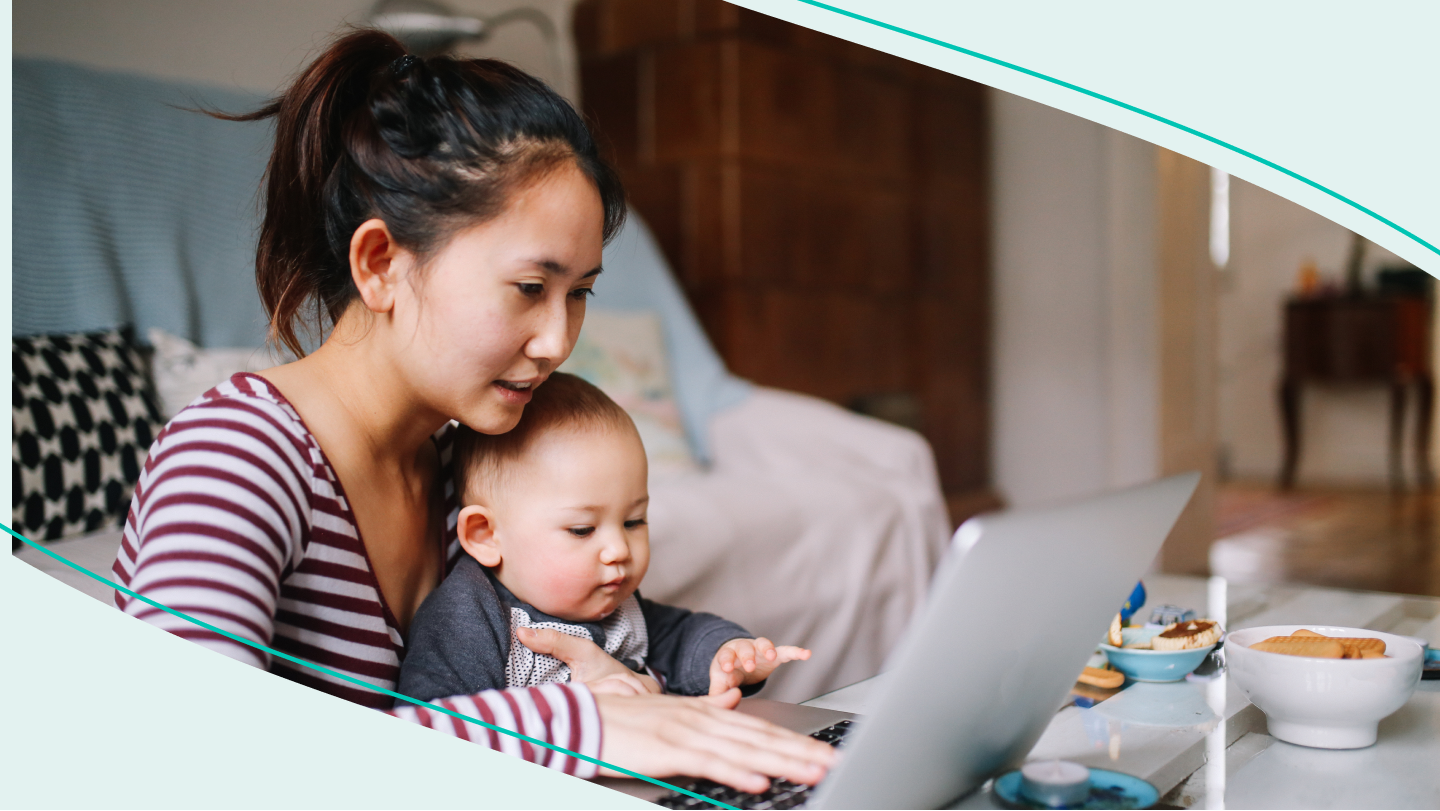 Woman works on laptop while a baby sits in her lap