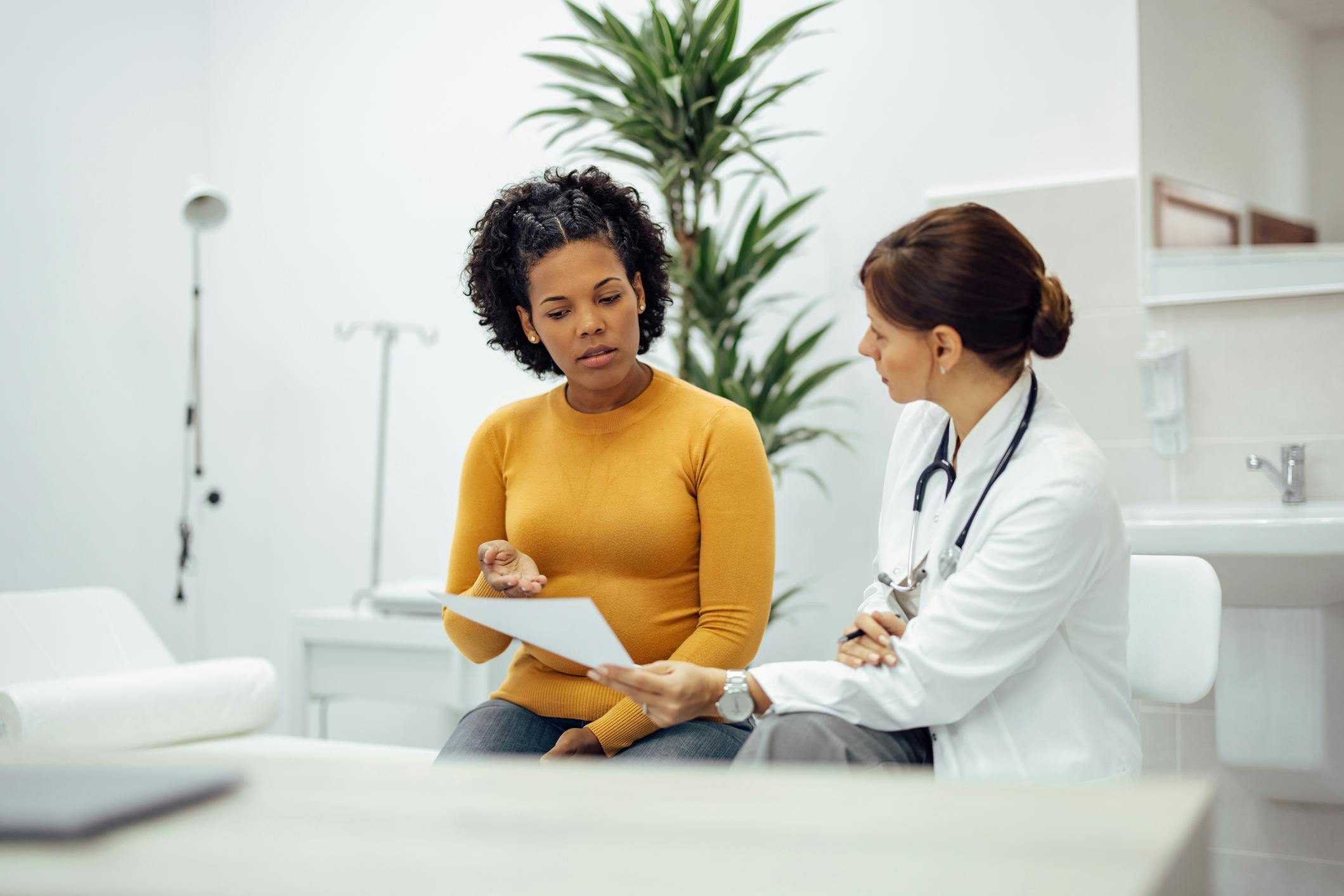 A woman sitting and talking with her doctor