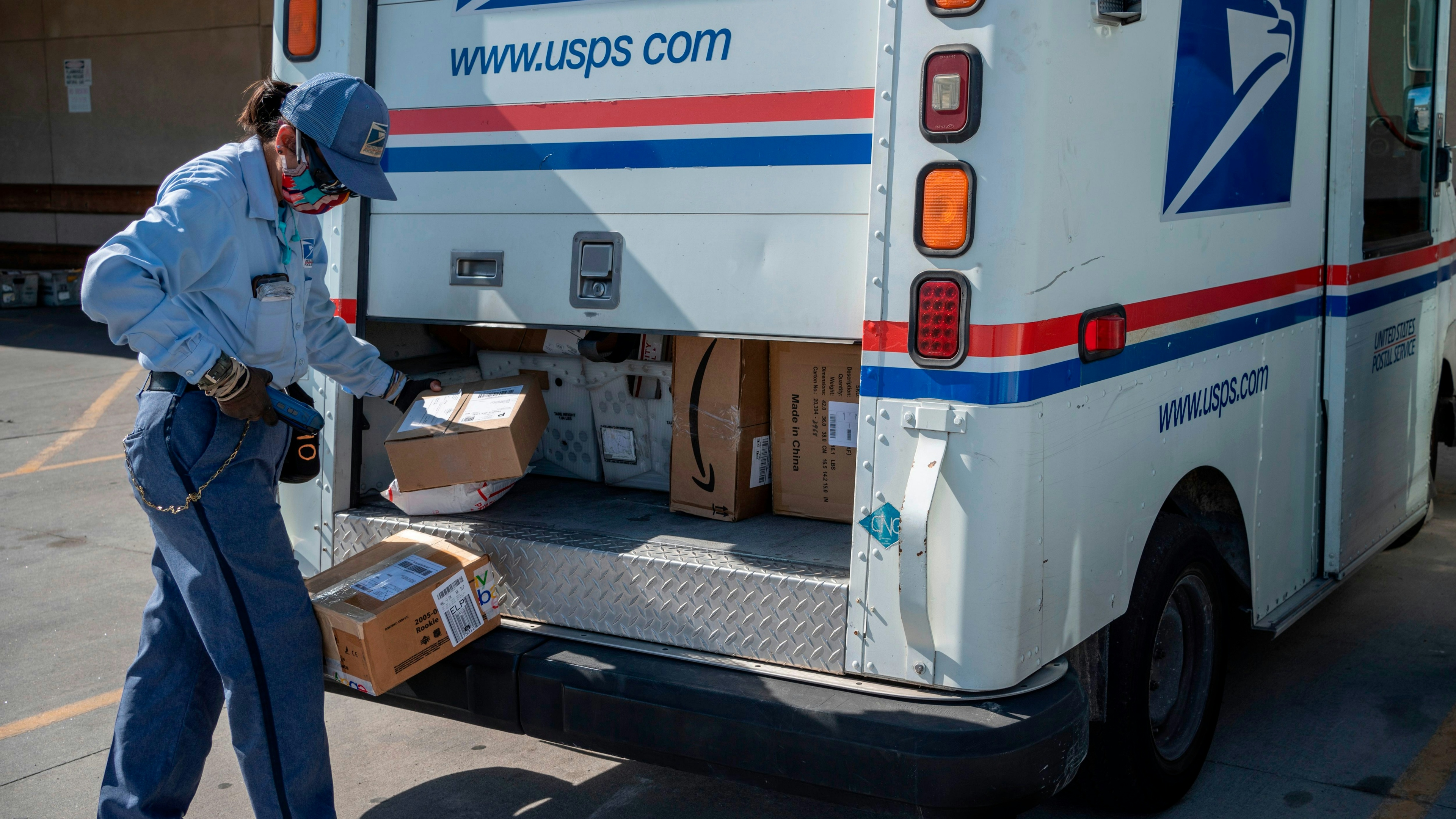 United States Postal Service mail carrier Lizette Portugal finishes up loading her truck