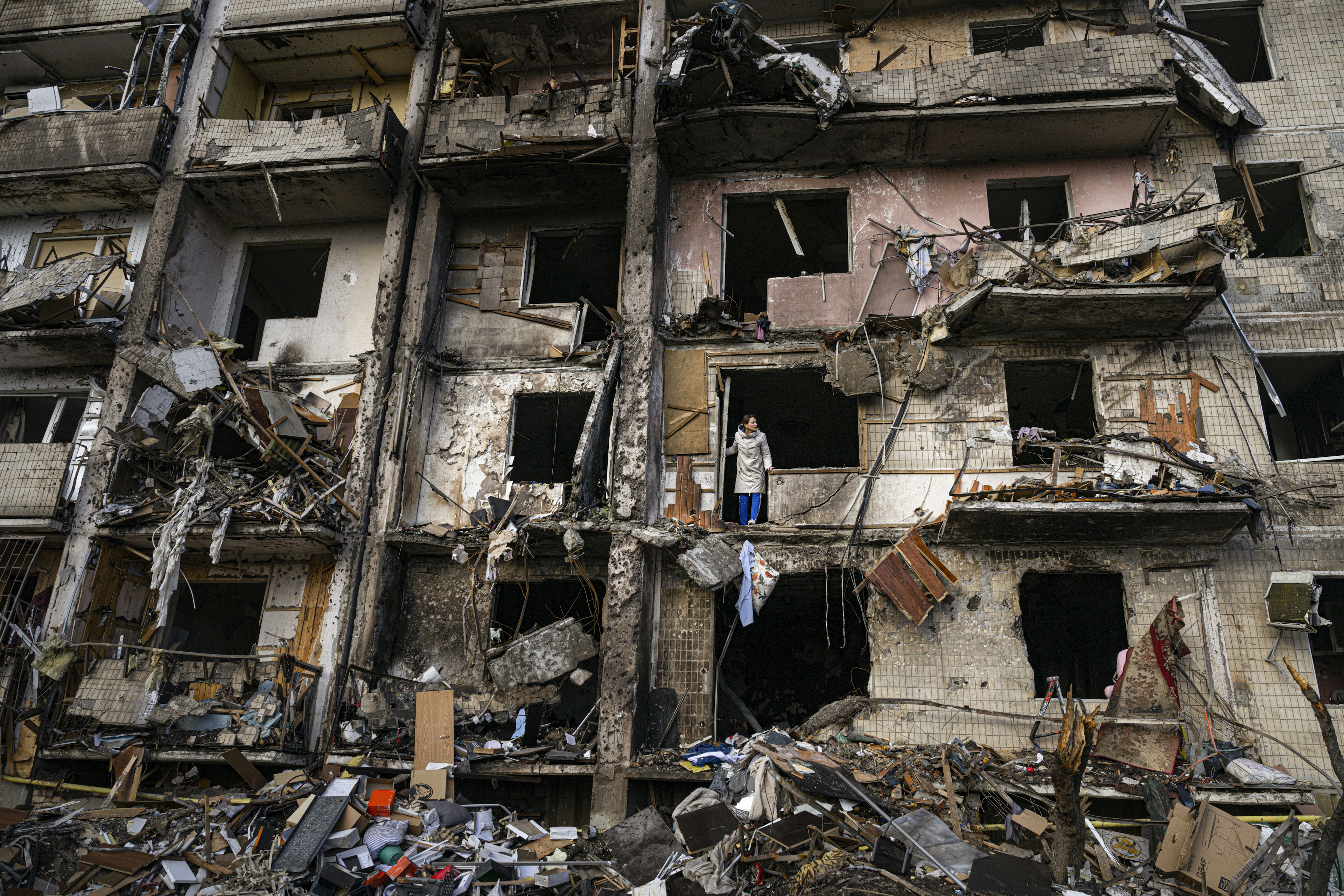 A woman surveys damage to a residential building that was destroyed by missiles in south Kyiv on February 25, 2022.
