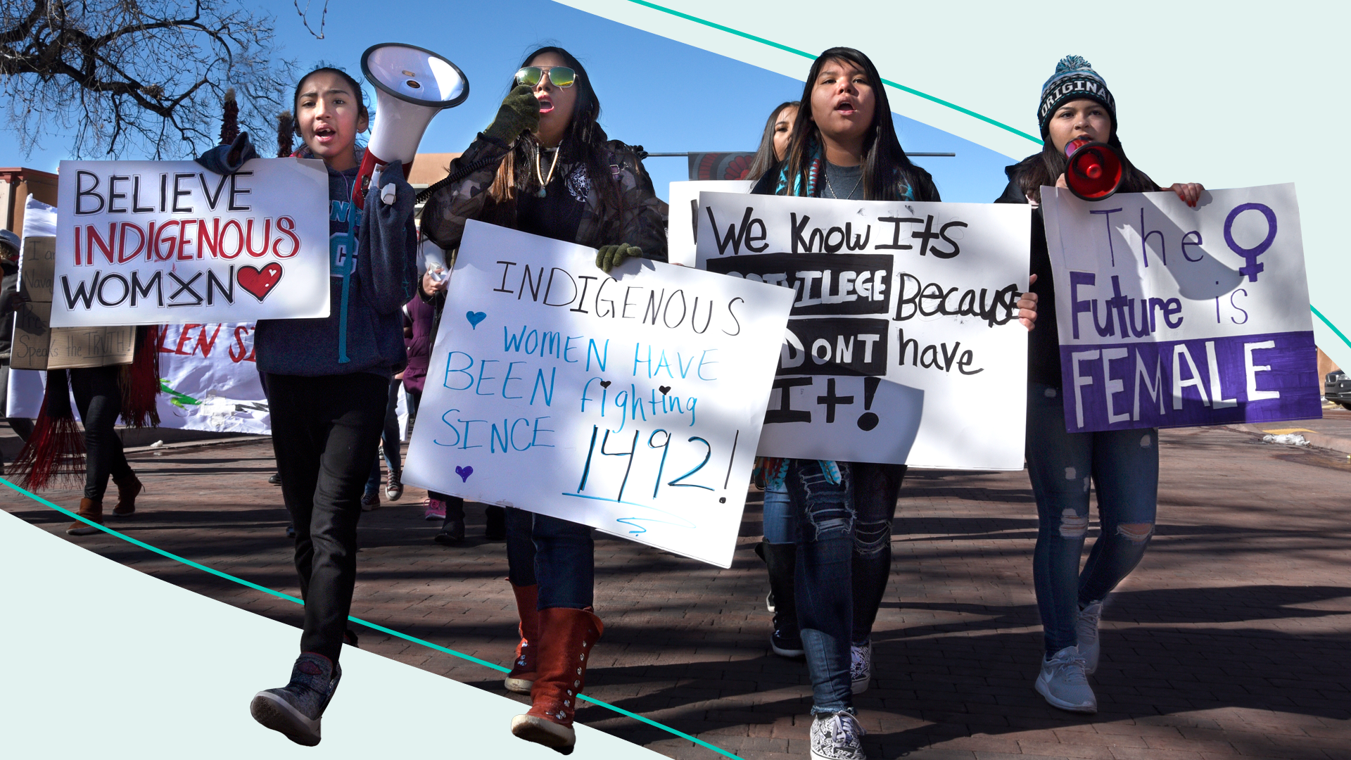 Native American participants in the Women's March walk with signs and bullhorns in Santa Fe, New Mexico.
