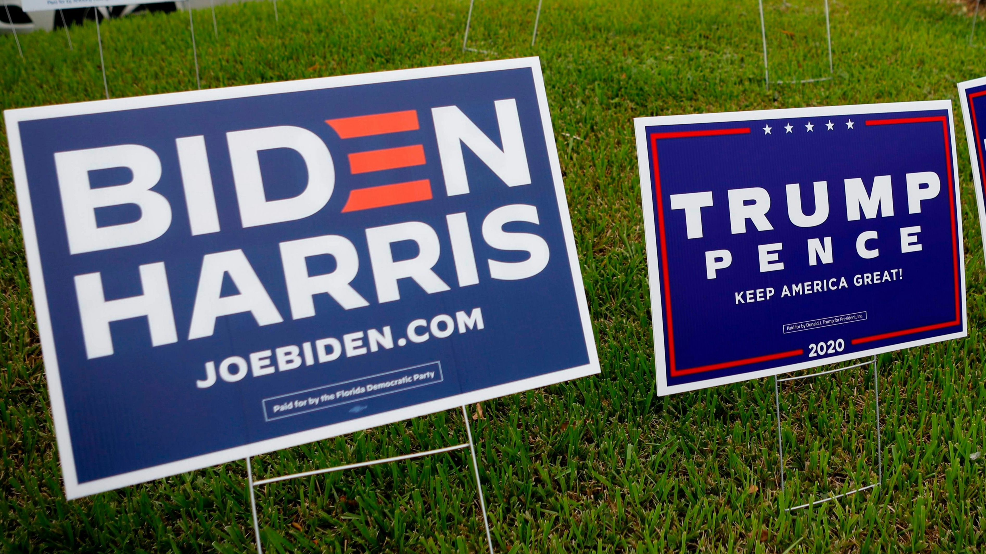 Joe Biden and President Trump's campaign signs sit side by side at a polling location in Florida.