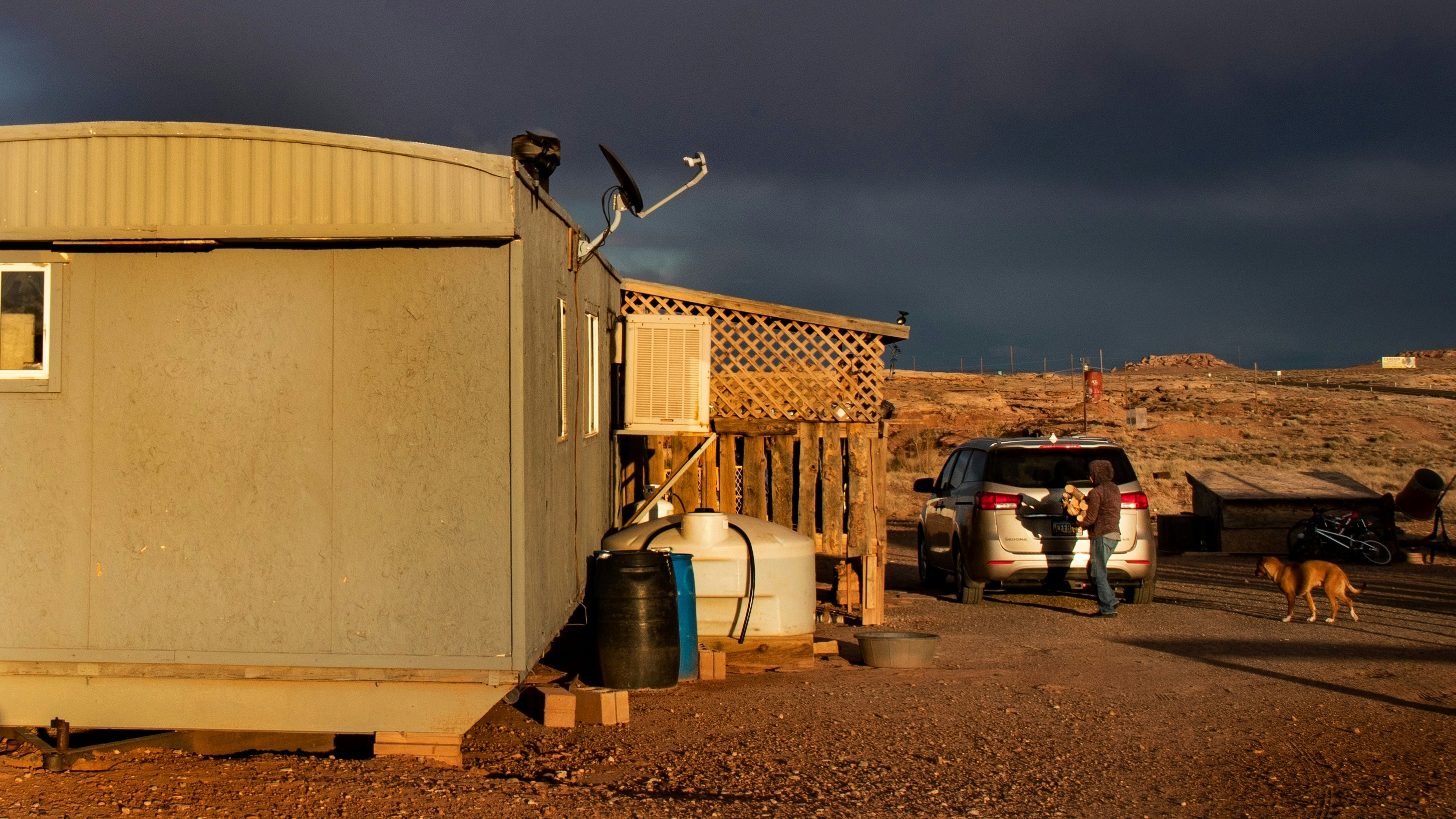 A Navajo woman carries wood to heat her rural mobile home during the coronavirus pandemic in Cameron, Arizona.