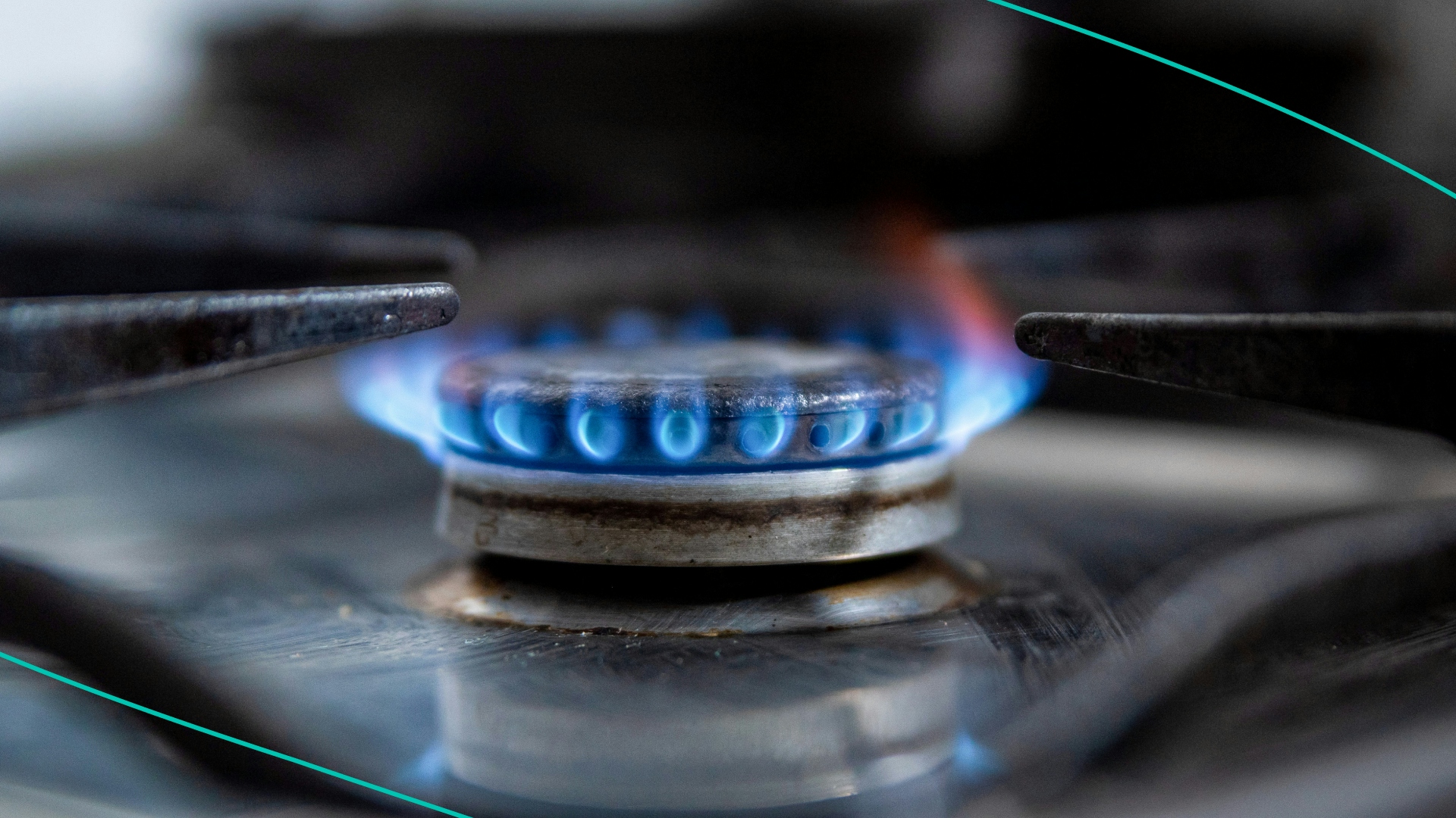 A gas stove lets off a blue flame inside a household kitchen 