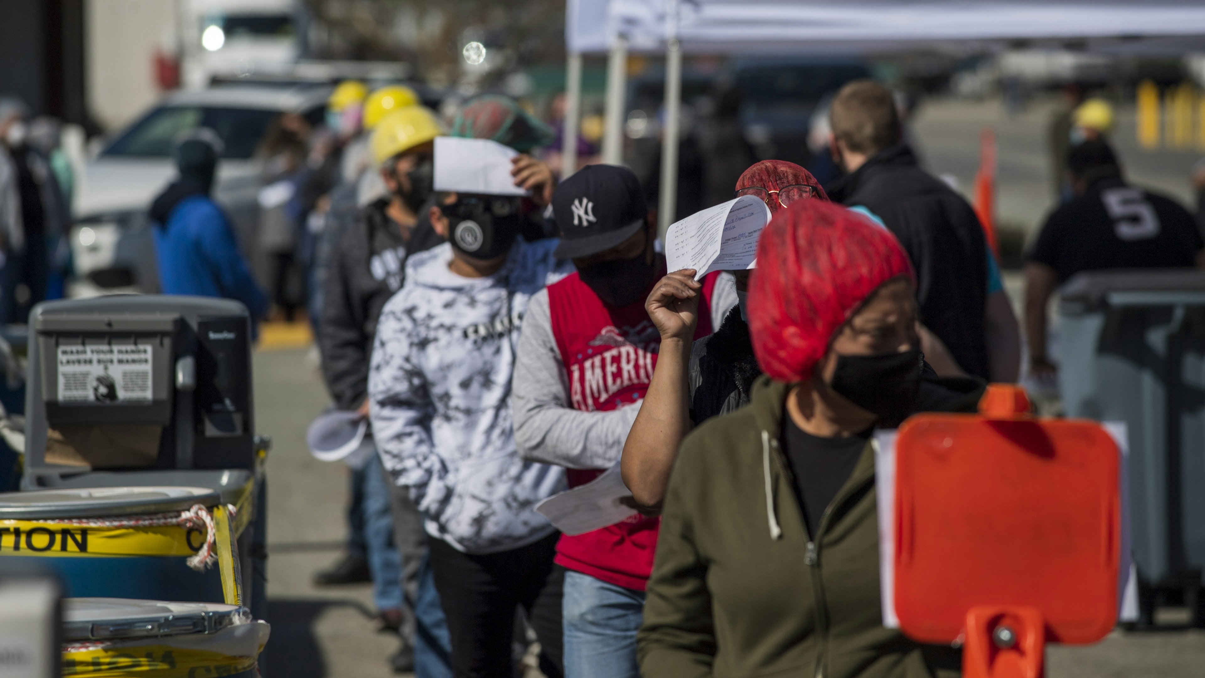 Farmworkers wait in line to receive the Moderna Covid-19 vaccine at a vaccination clinic organized by the Santa Clara County Public Health Department at Christopher Ranch in Gilroy, California, U.S., on Thursday, March 4, 2021.