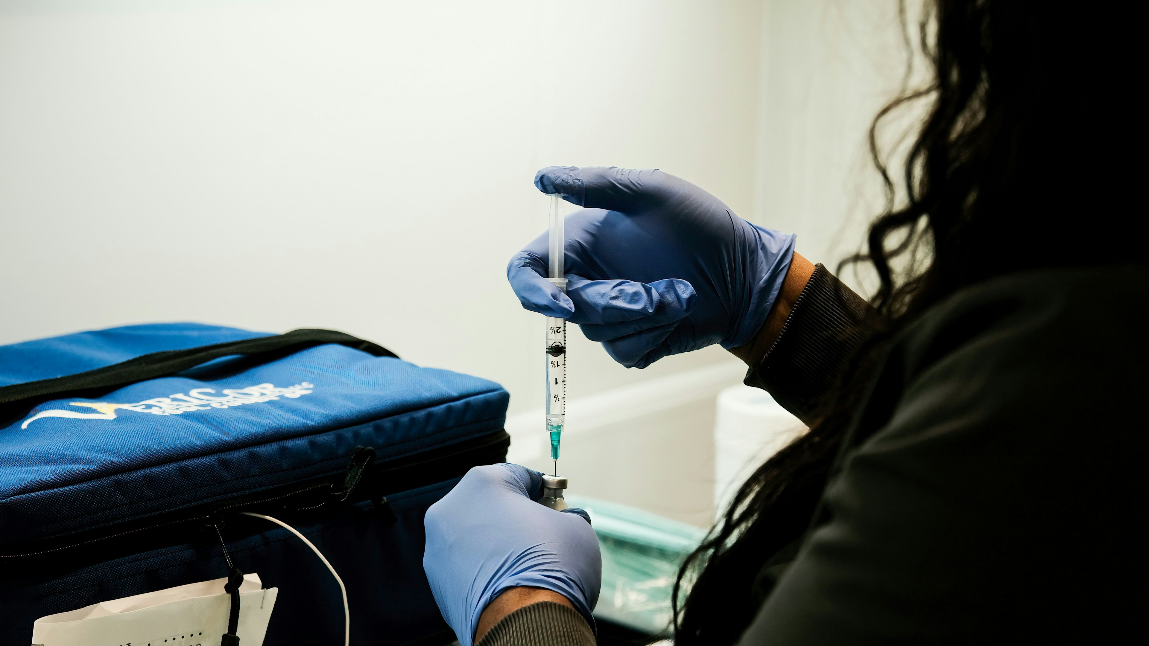 Health Care Workers from the Detroit Health Department prepare a dose of the Pfizer Covid-19 vaccine