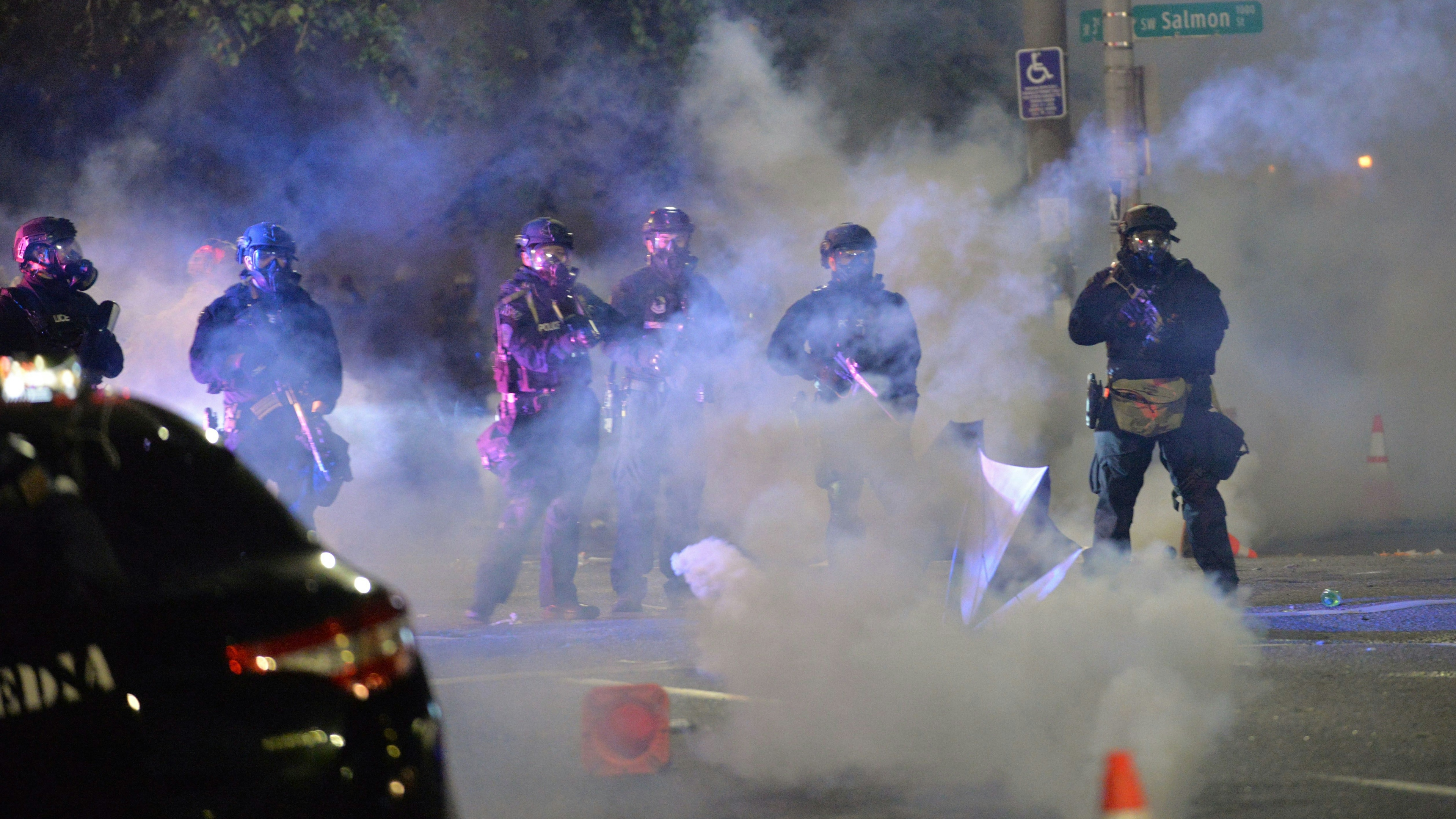 Security personnel stand in a cloud of tear gas in Portland, Oregon early July 26, 2020, as protests continue across the United States.