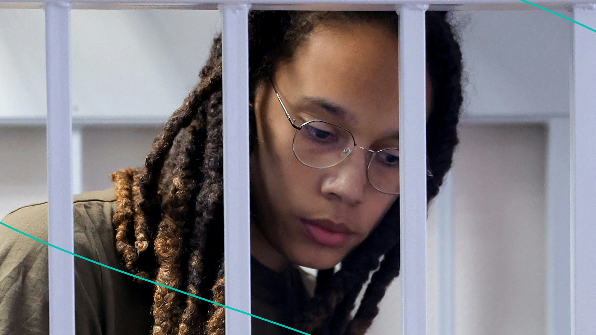 Brittney Griner stands in a defendants' cage before a court hearing