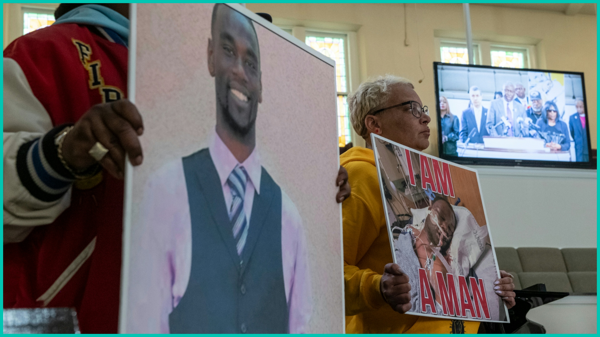 Activists hold signs showing Tyre Nichols as attorney Ben Crump is seen speaking on a monitor during a press conference at Mt. Olive Cathedral CME Church