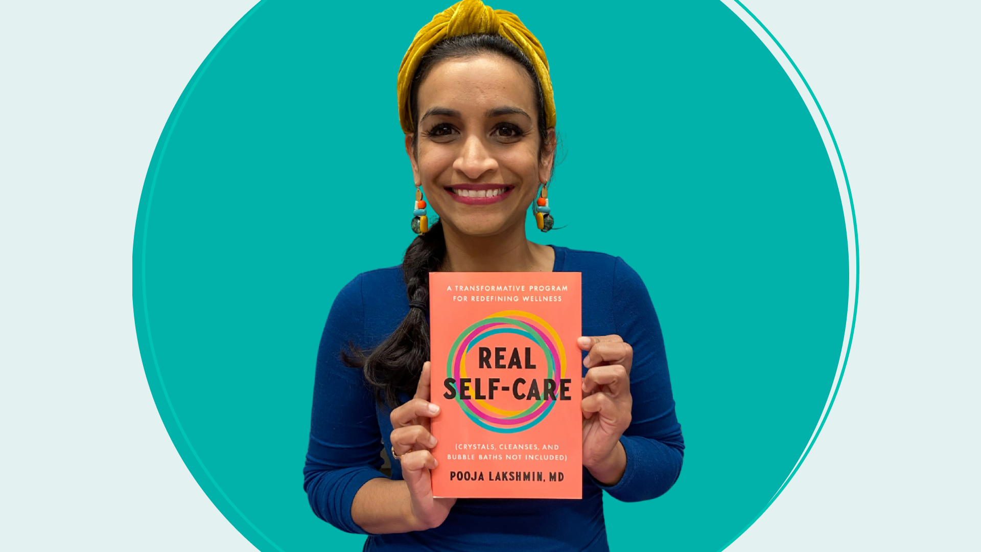 Pooja Lakshmin holding her book "Real Self-Care"