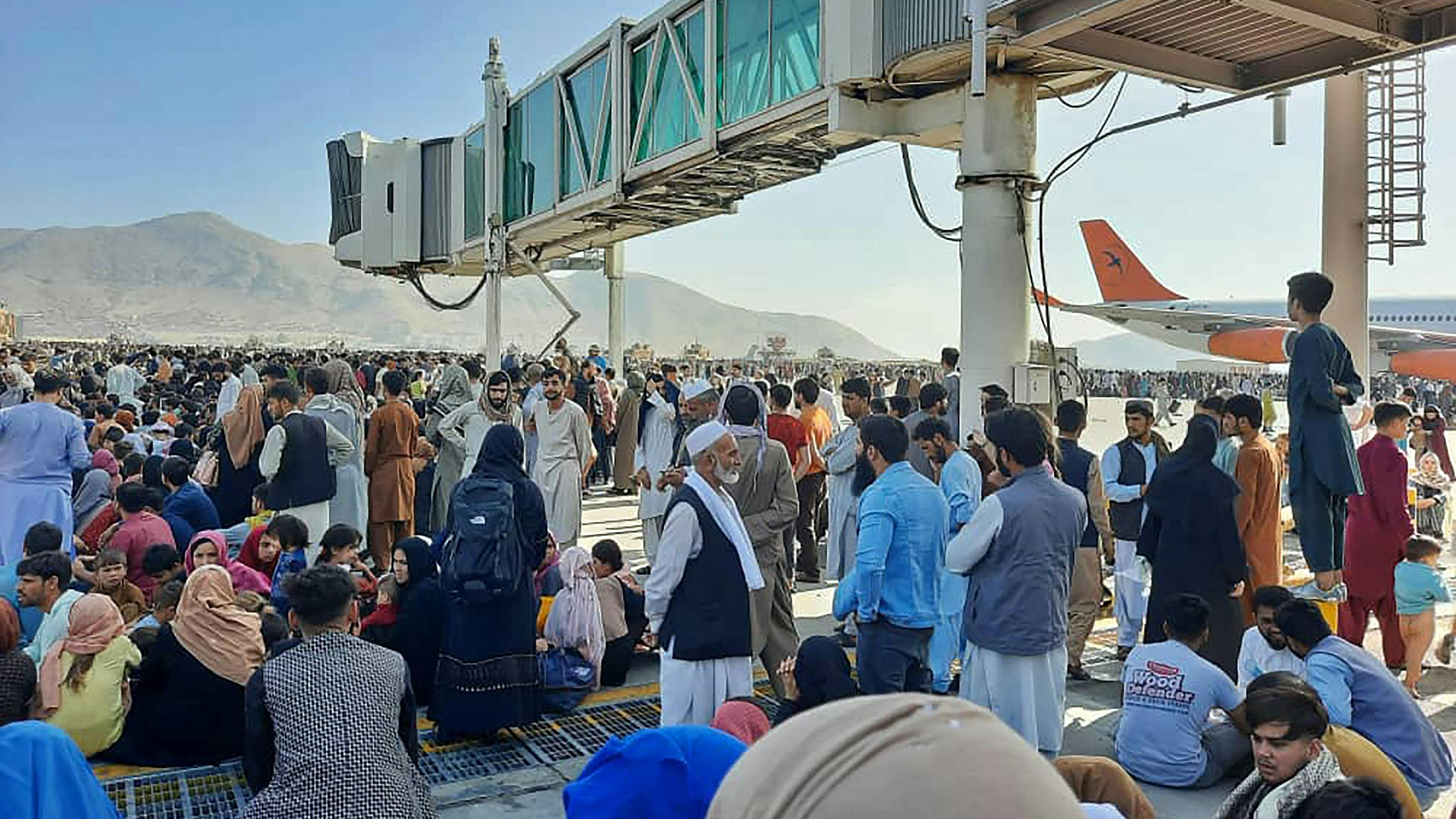 Afghans crowd at the tarmac of the Kabul airport on August 16, 2021, to flee the country as the Taliban were in control of Afghanistan after President Ashraf Ghani fled the country and conceded the insurgents had won the 20-year war. 