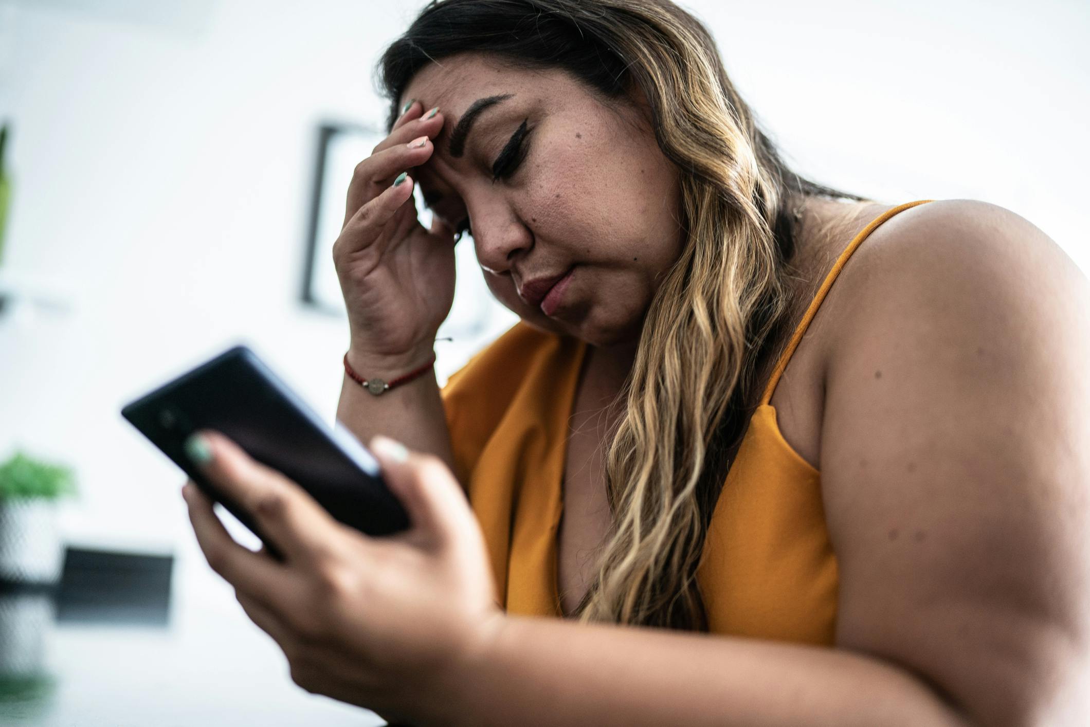 A woman looking at her phone looking distressed