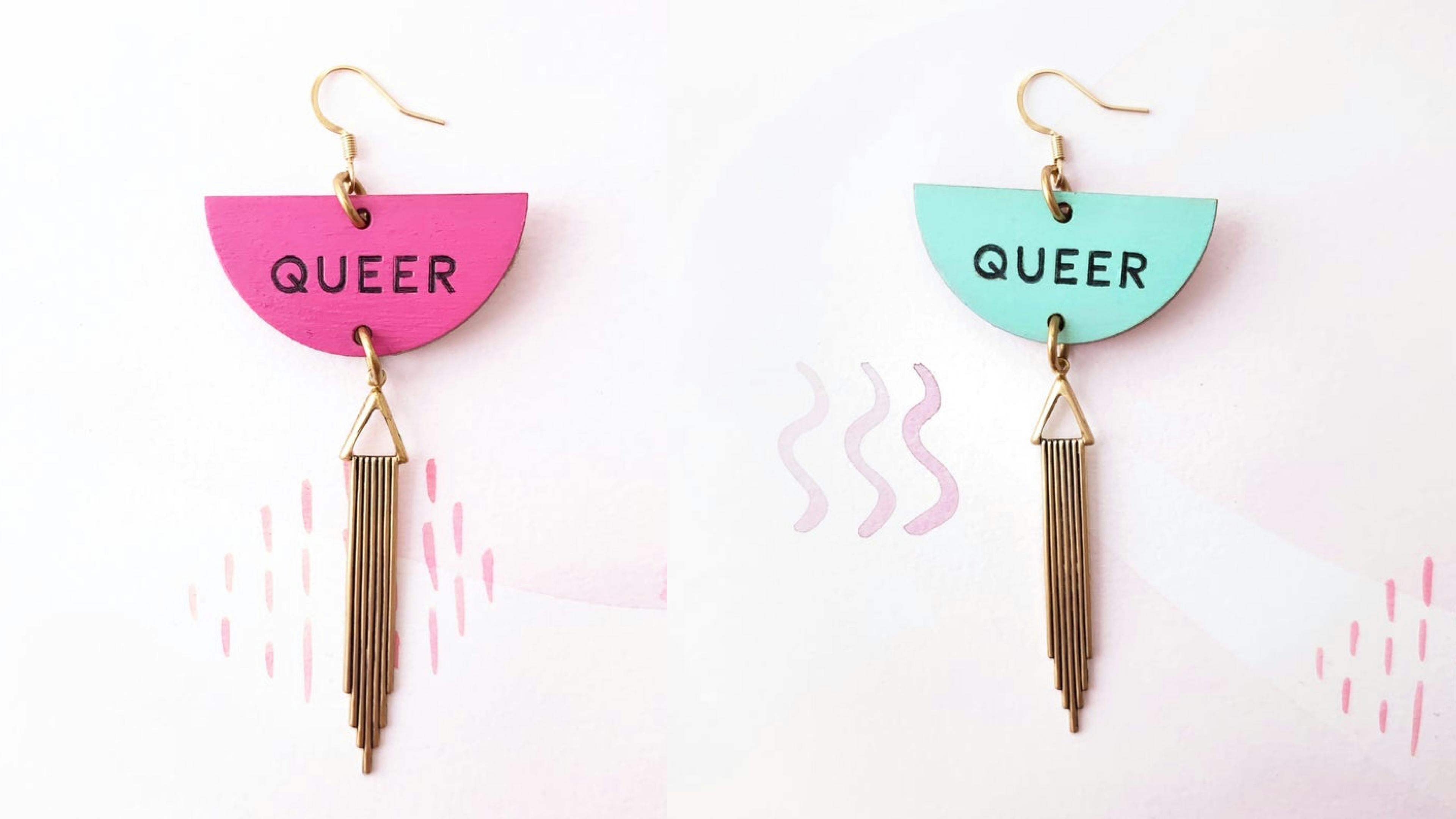 blue and pink hanging earrings with the word queer