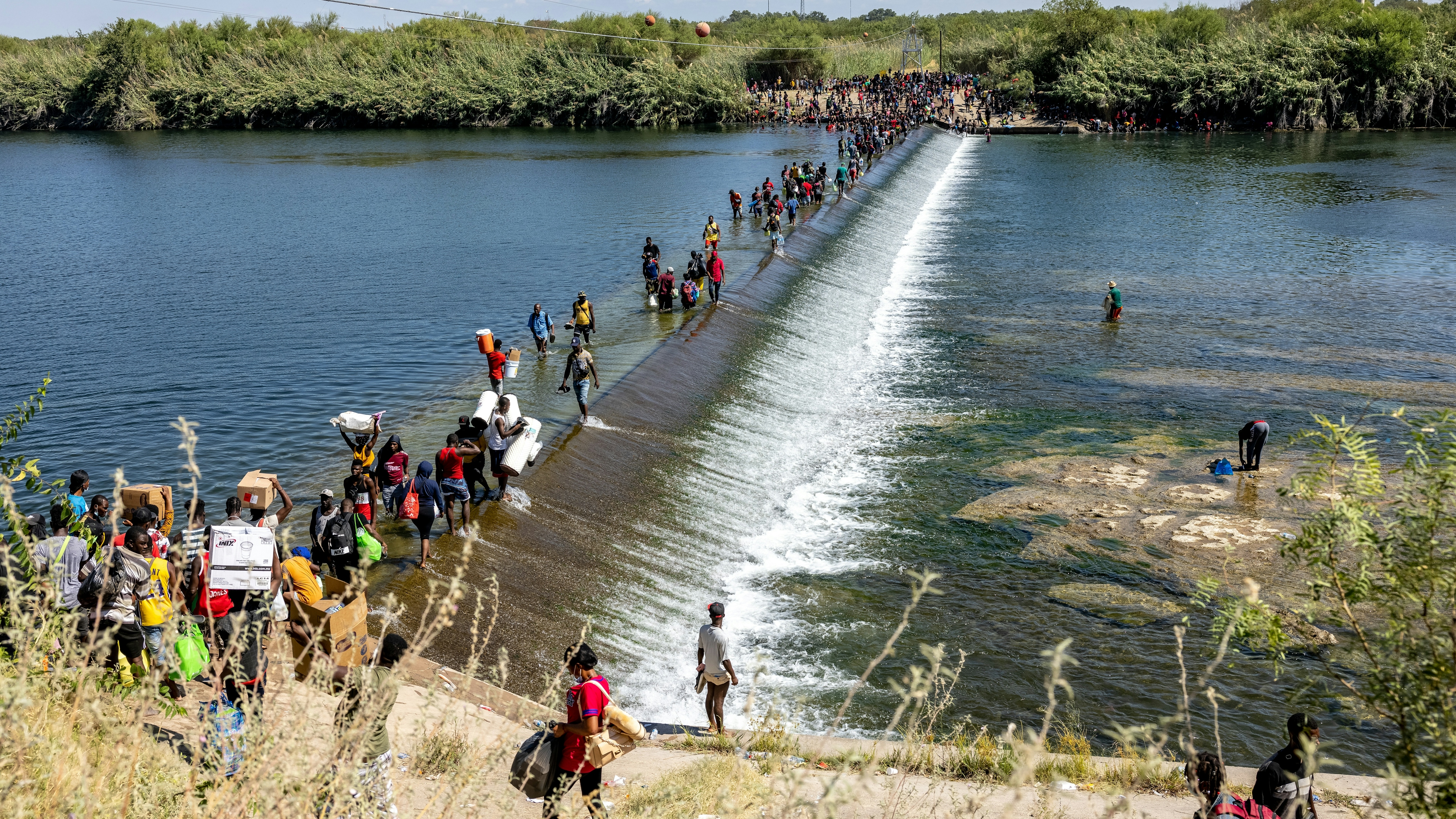 Migrants walk across the Rio Grande River in Del Rio, Texas in September 2021.