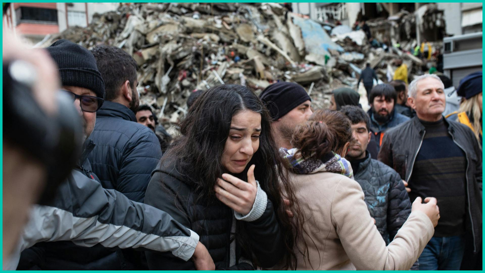 A woman reacts as rescuers search for survivors through the rubble of collapsed buildings in Adana, on February 6, 2023 after a 7,8 magnitude earthquake struck the country's south-east.