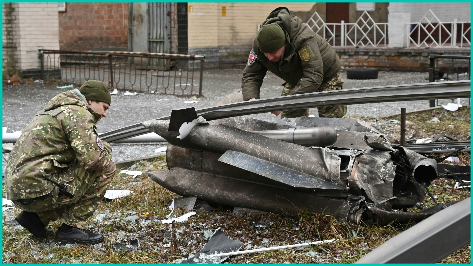 Police and security personnel inspect the remains of a shell in a street in Kyiv