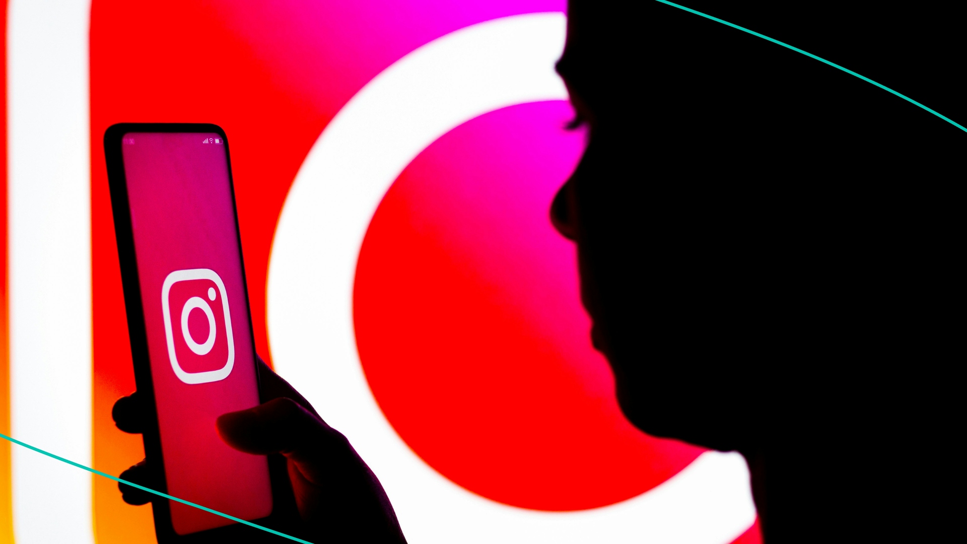 A woman's silhouette holds a smartphone with the Instagram logo displayed on the screen and in the background.