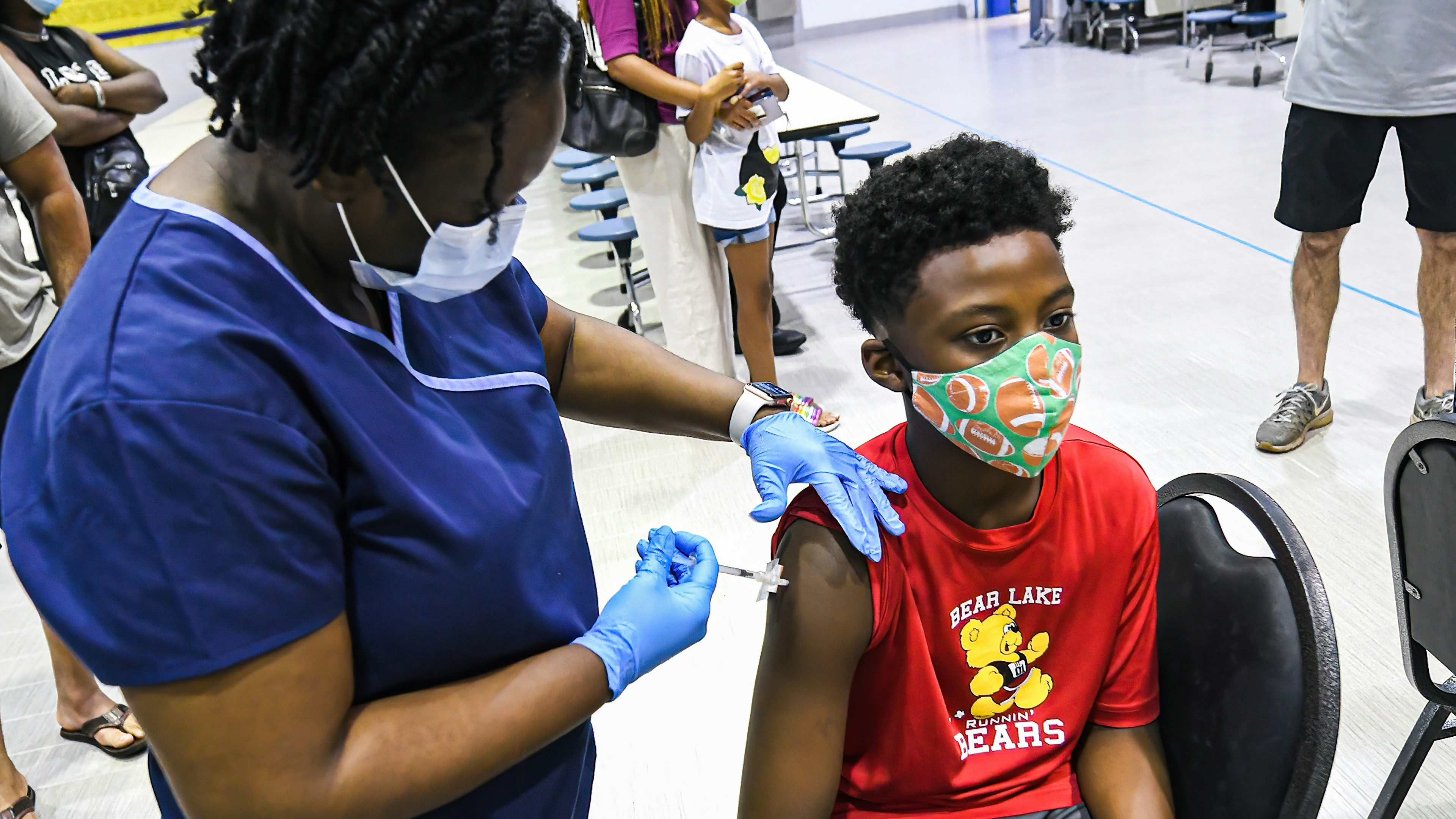 A nurse gives a boy a dose of the Pfizer vaccine at a COVID-19 vaccine clinic