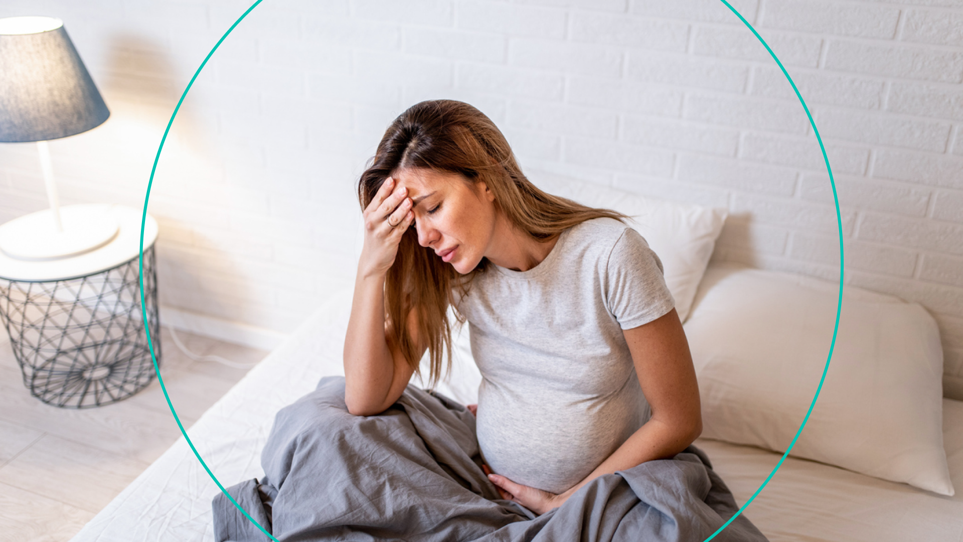 Woman Holding Pregnant Stomach in Bed