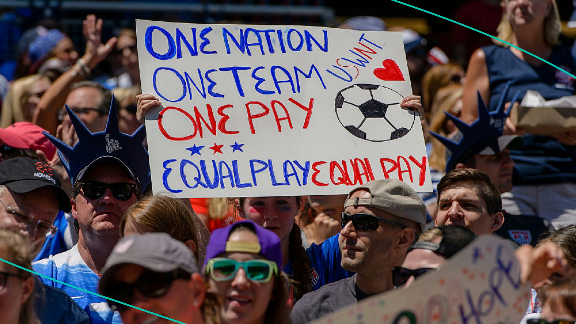 Fan holding equal pay sign at soccer game