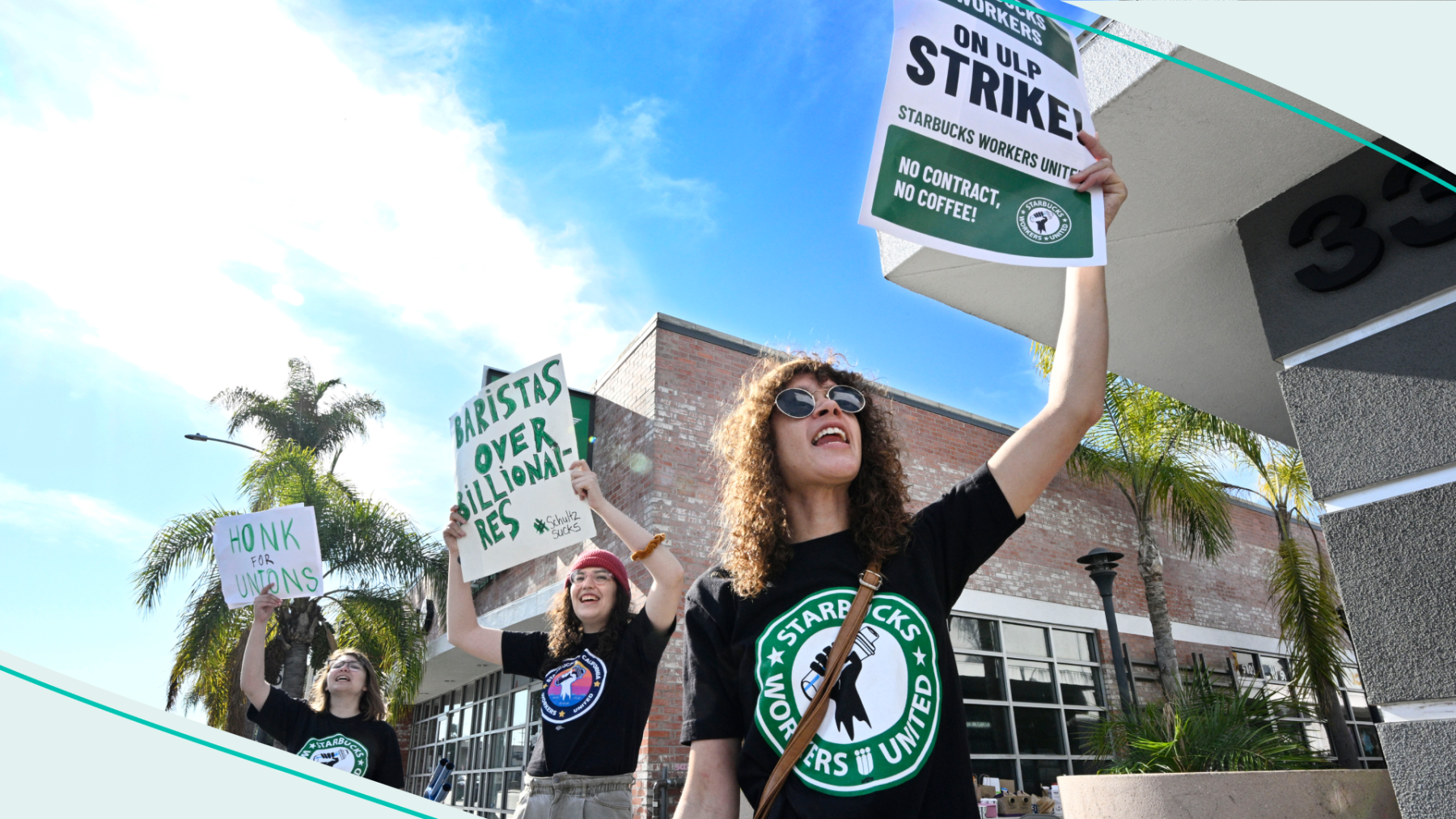 Starbucks employees hold picket signs as they strike in front of a Starbucks store.