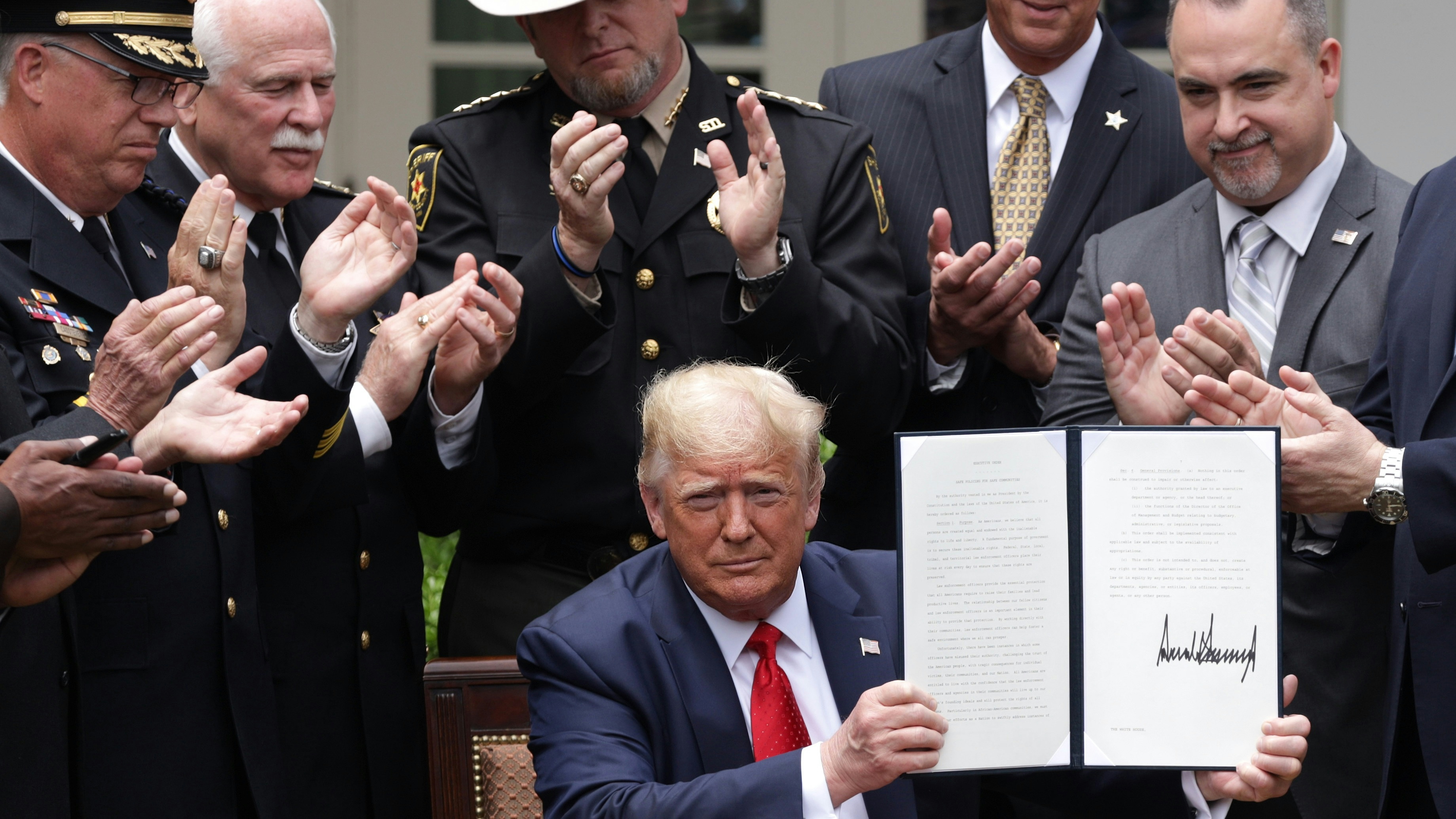 President Trump holds up an executive order he signed on “Safe Policing for Safe Communities” on June 16th, 2020.
