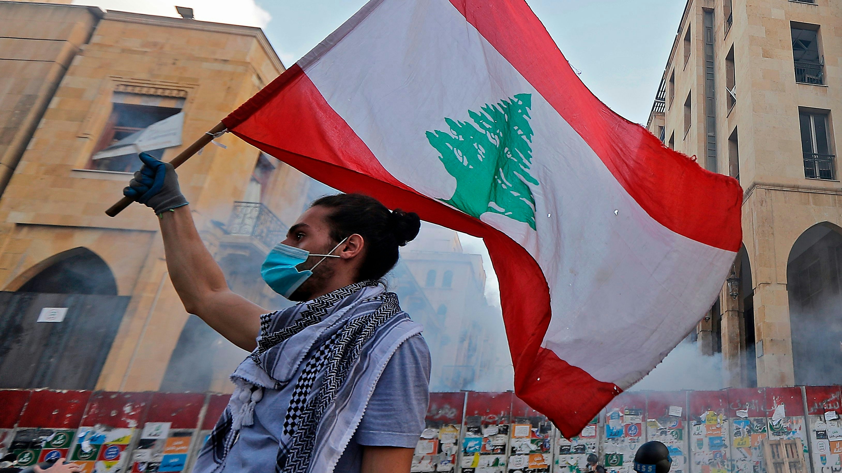 A Lebanese protester waves a national flag amid clashes with security forces