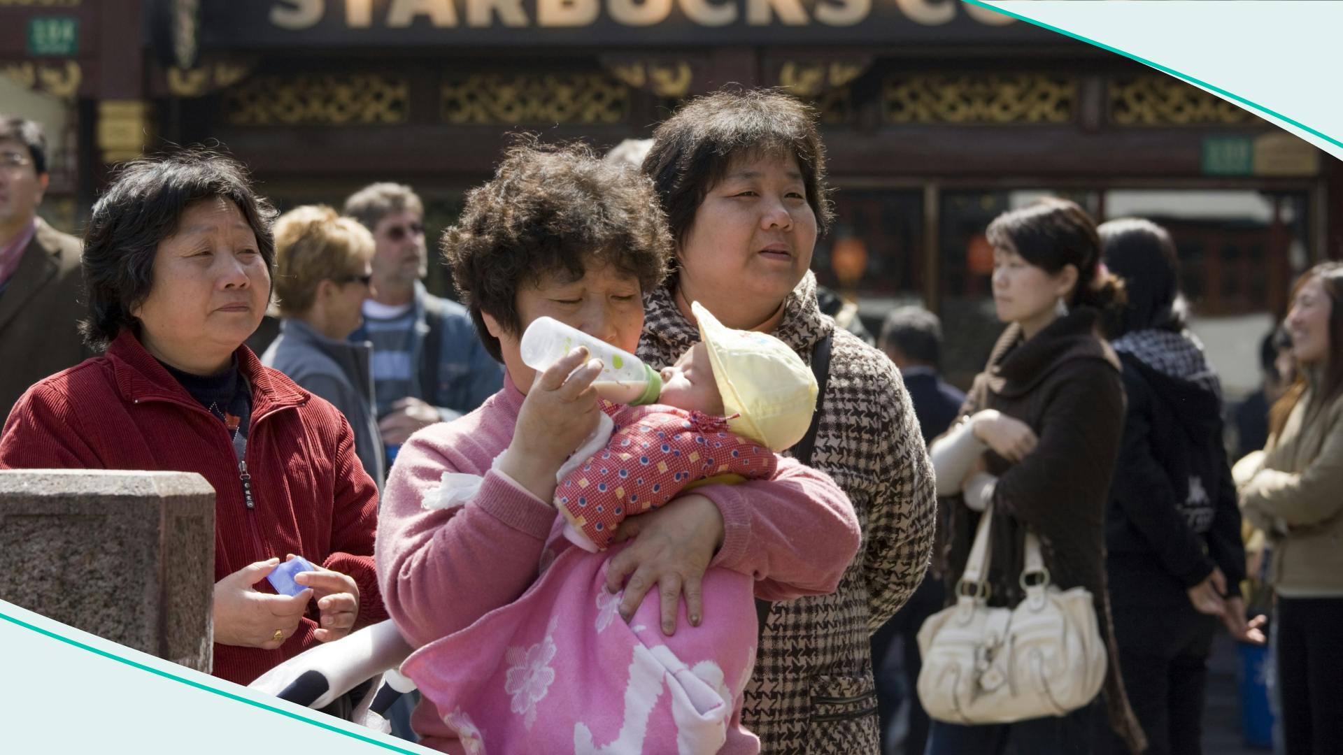 Woman feeds baby outside Starbucks in the Yu Garden Bazaar