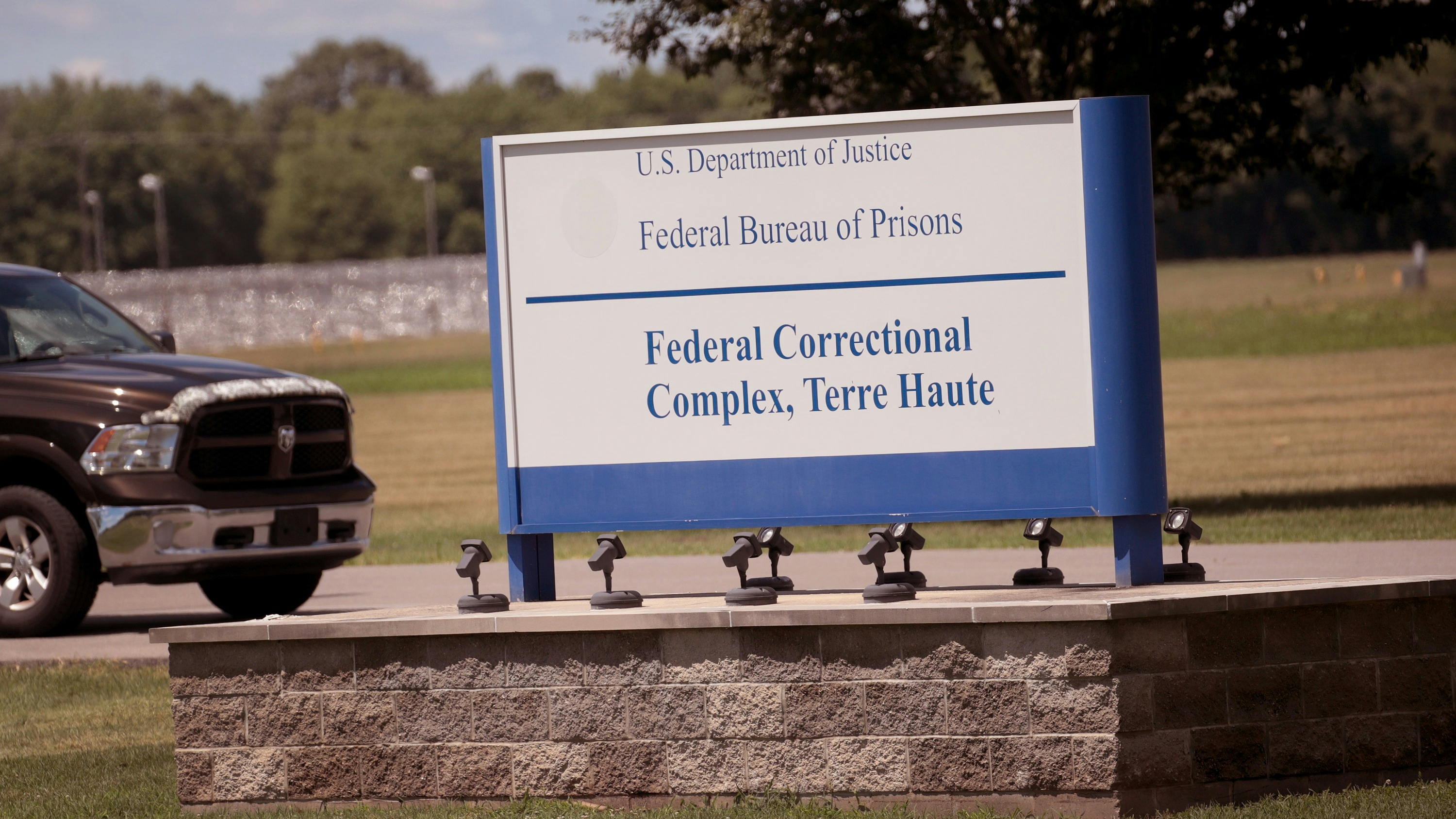 A sign sits at the entrance of the Federal Correctional Complex