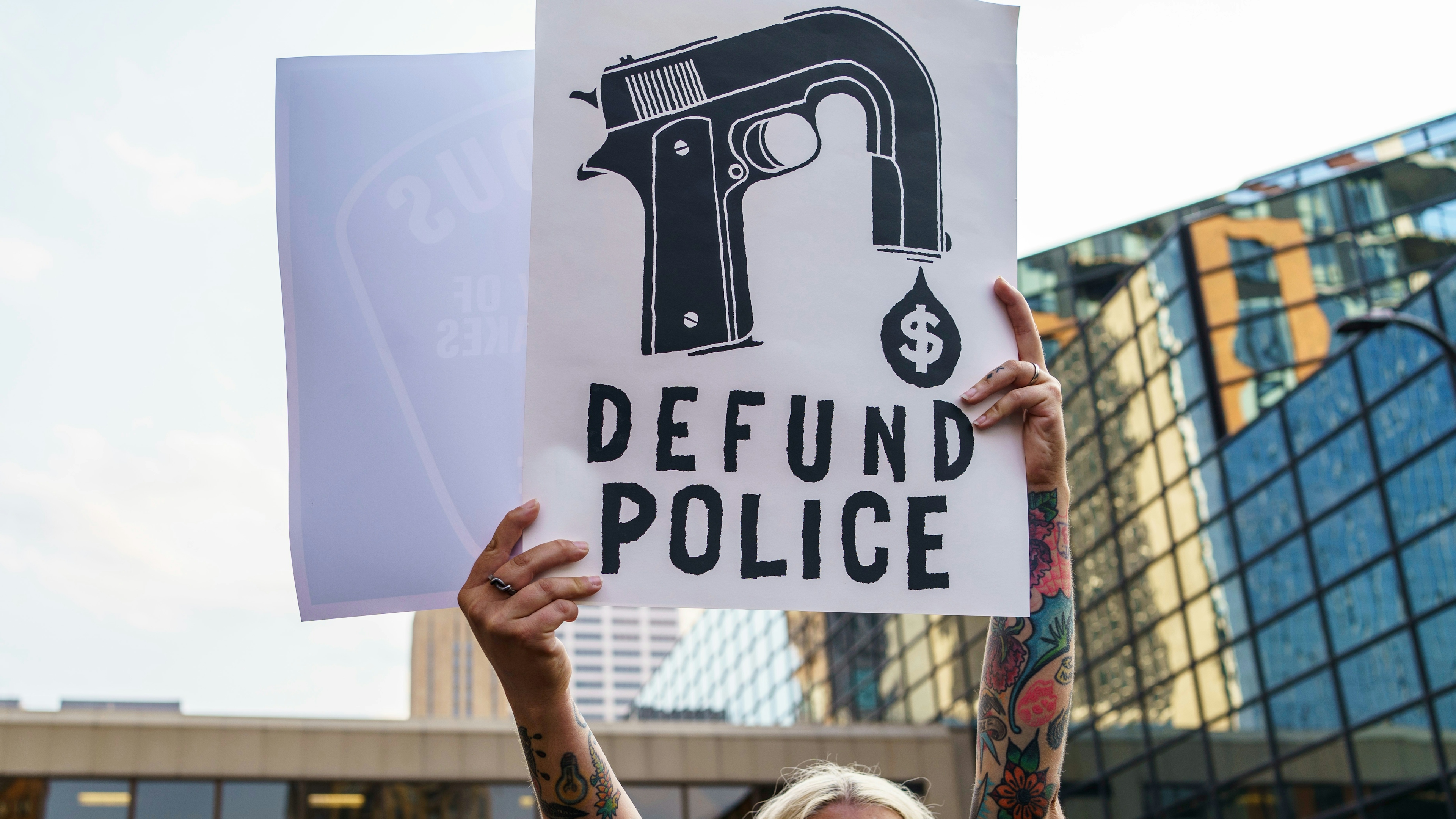 A protester hold a sign reading "Defund the Police" during a demonstration against police brutality and racism in Minneapolis, Minnesota.