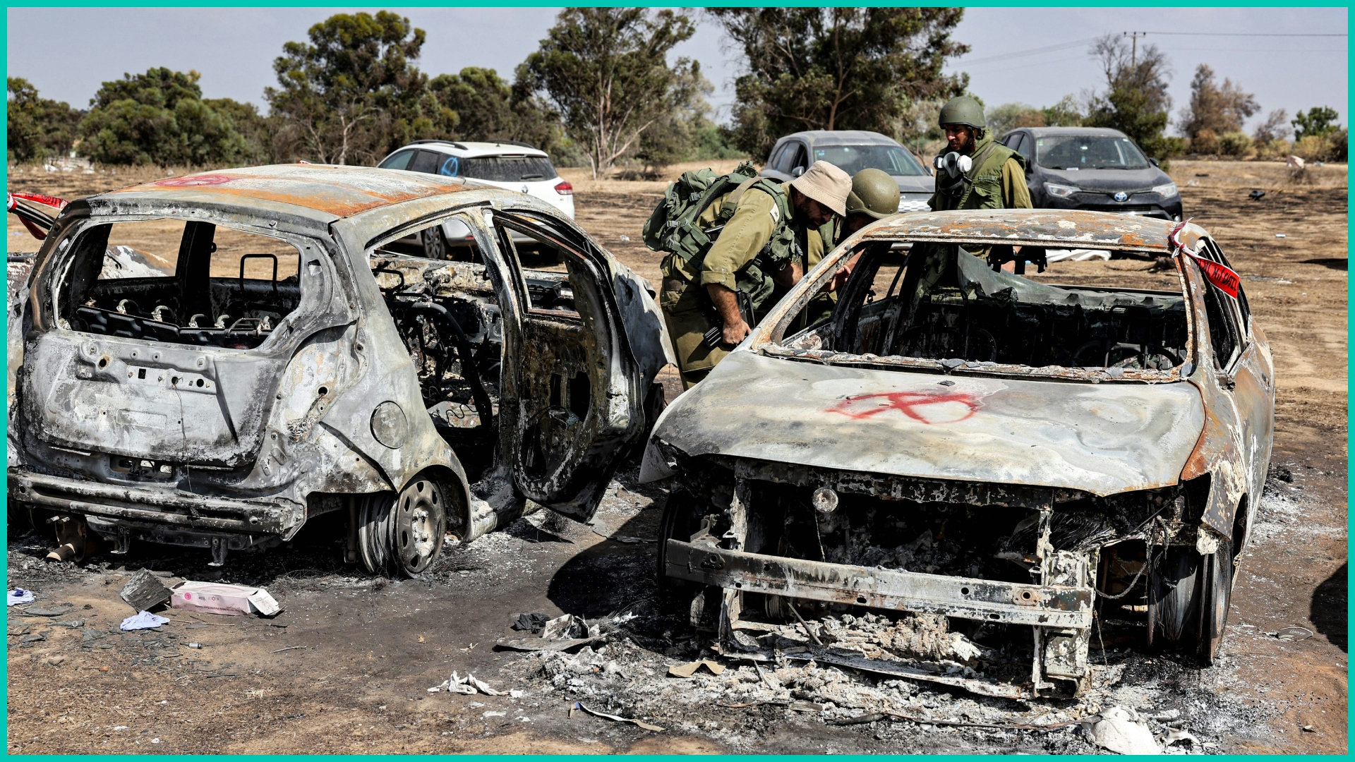 Israeli soldiers near a kibbutz in southern Israel search vehicles torched by Hamas during its  Oct. 7, 2023 attack on Israel.